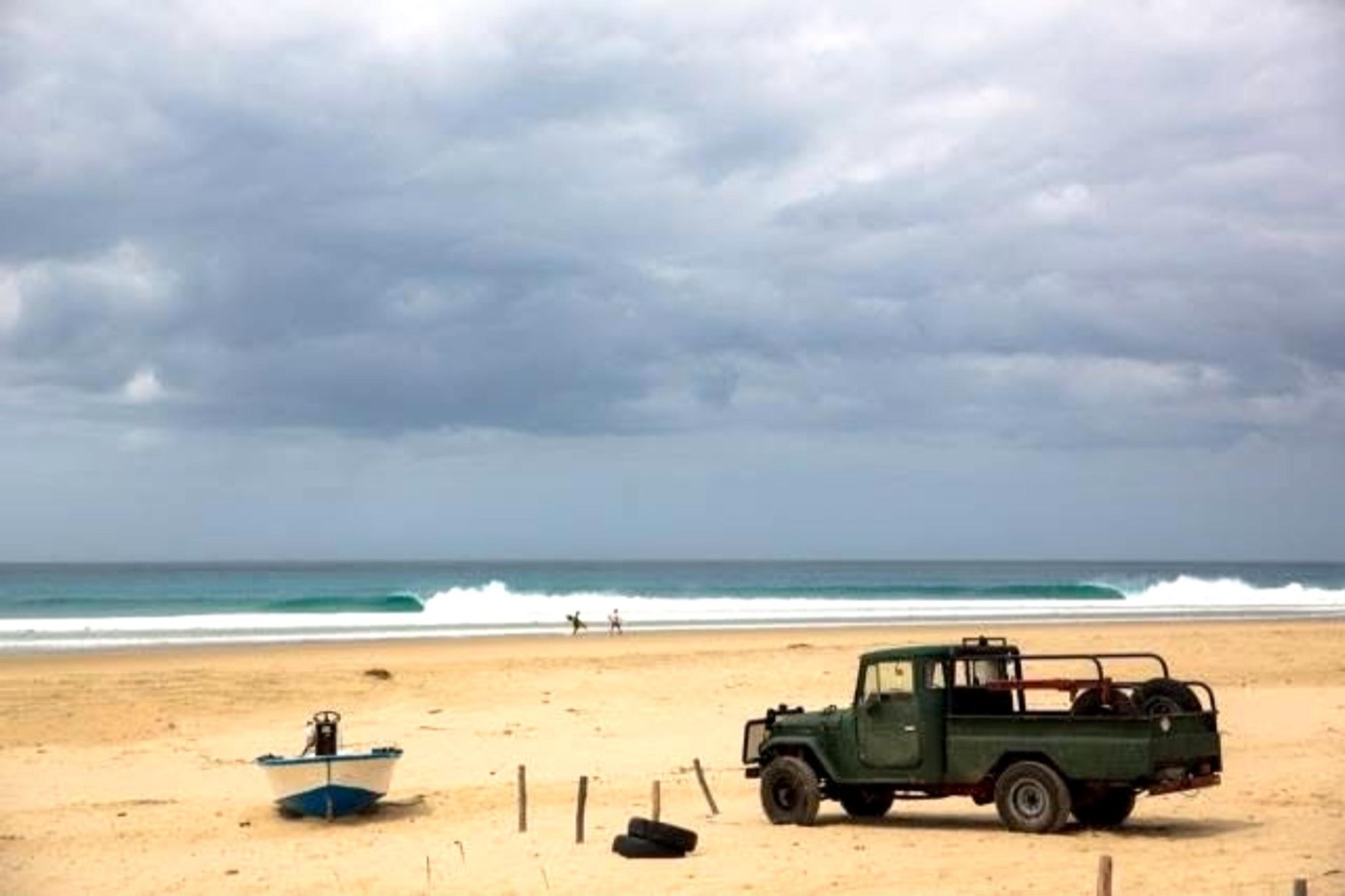 Land Rover and boat on an empty beach